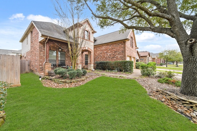 view of front of home with brick siding, a front yard, fence, a garage, and stone siding