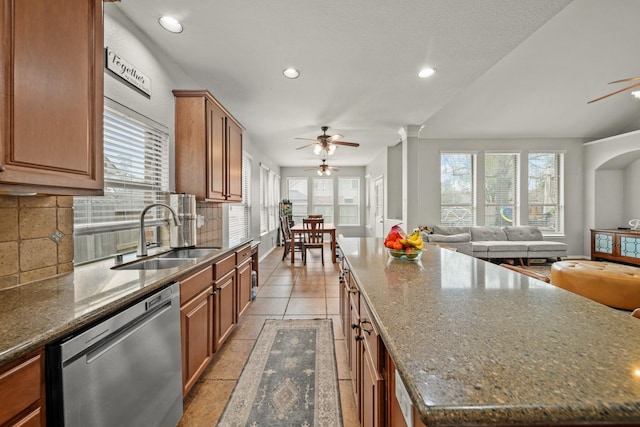 kitchen with a sink, a ceiling fan, open floor plan, backsplash, and dishwasher