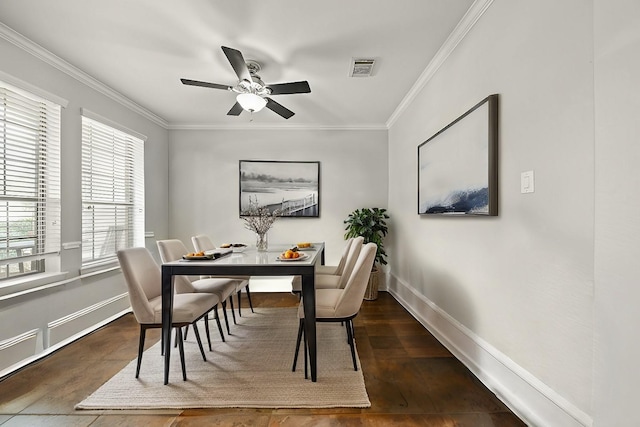 dining room with visible vents, ornamental molding, baseboards, and wood finished floors