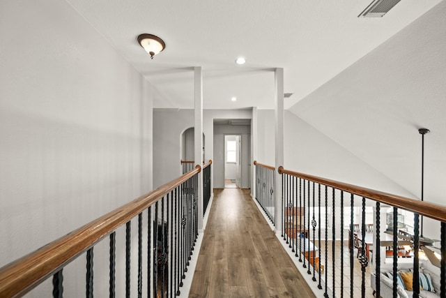 hallway featuring recessed lighting, visible vents, vaulted ceiling, and wood finished floors