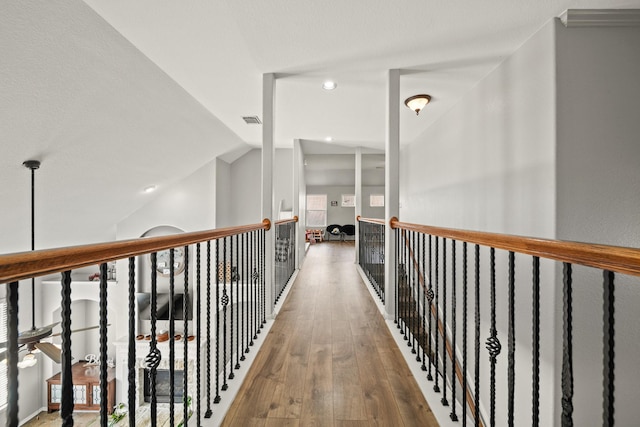 hallway with vaulted ceiling, visible vents, hardwood / wood-style flooring, and recessed lighting