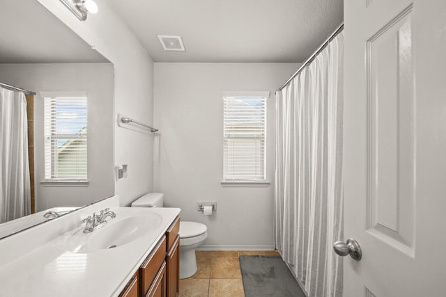 bathroom featuring toilet, vanity, visible vents, and baseboards