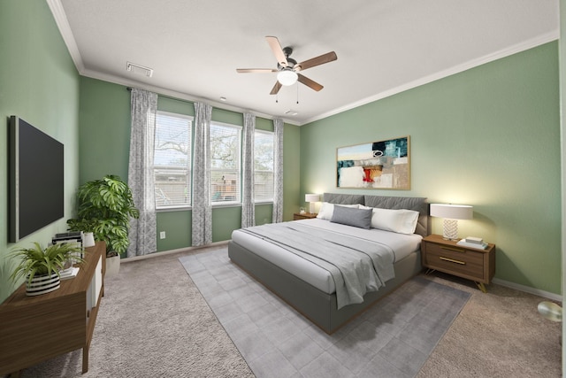 carpeted bedroom with baseboards, visible vents, ornamental molding, and a ceiling fan