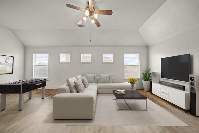 living area with vaulted ceiling, ceiling fan, light wood-type flooring, and visible vents