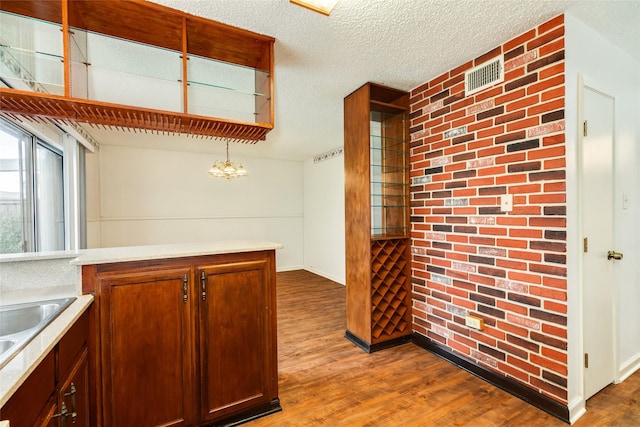 kitchen with dark wood-type flooring, light countertops, visible vents, and a textured ceiling