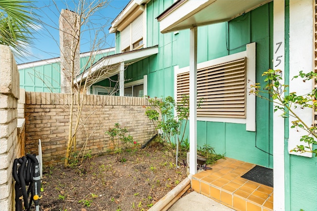 view of side of property with board and batten siding and fence