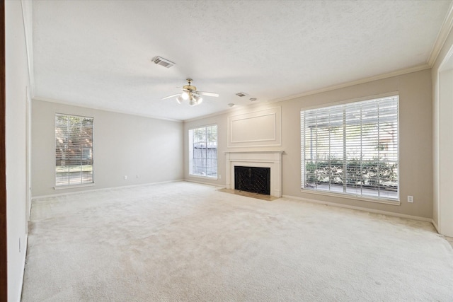 unfurnished living room with light carpet, visible vents, a fireplace with flush hearth, ornamental molding, and a textured ceiling