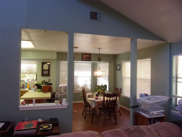 dining room with lofted ceiling, a wealth of natural light, tile patterned flooring, and visible vents