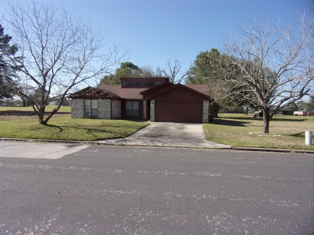 view of front facade with a garage, a front yard, brick siding, and driveway