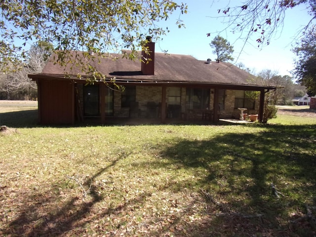 back of property with a yard and a chimney