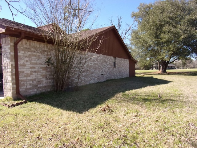 view of home's exterior with a yard and brick siding