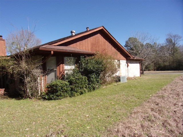 view of side of home with a lawn and central AC unit