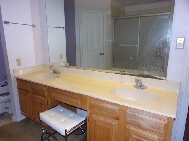 bathroom with double vanity, a shower stall, toilet, and a sink