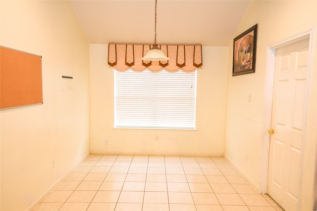 unfurnished dining area with lofted ceiling and light tile patterned floors