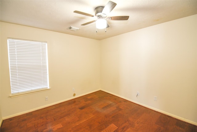 spare room featuring a ceiling fan, baseboards, visible vents, and wood finished floors