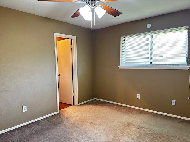 empty room with carpet floors, ceiling fan, and baseboards