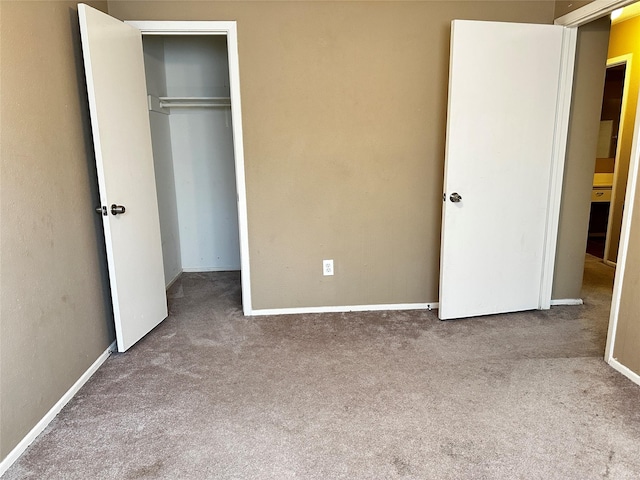 unfurnished bedroom with a closet, carpet flooring, and baseboards