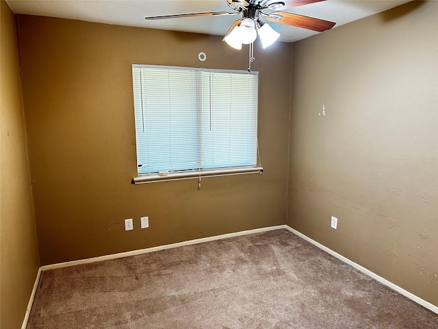 carpeted spare room featuring ceiling fan and baseboards