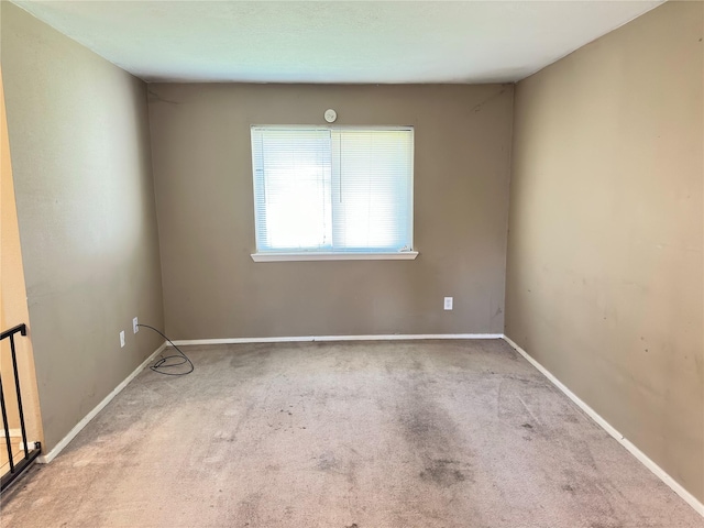 spare room with baseboards and carpet flooring