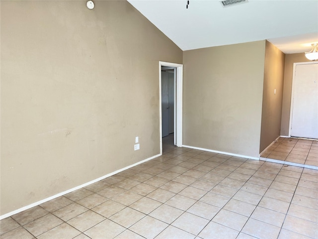 spare room with light tile patterned floors, baseboards, visible vents, and high vaulted ceiling