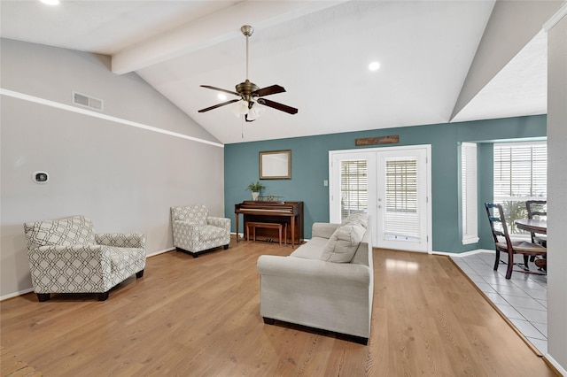 living area with light wood-type flooring, beam ceiling, visible vents, and baseboards