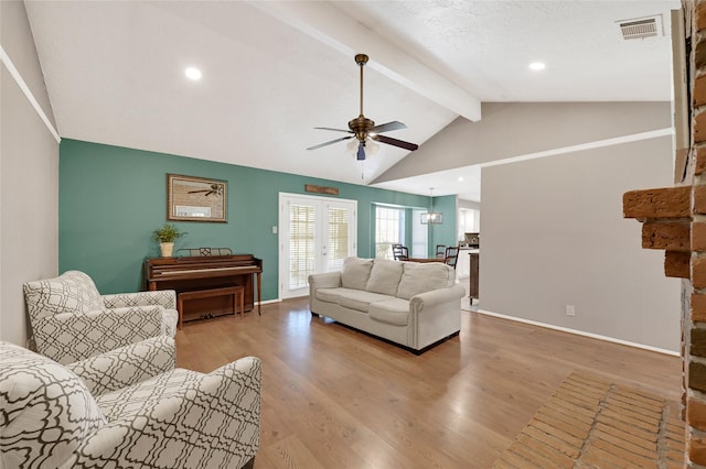 living area featuring light wood-type flooring, vaulted ceiling with beams, baseboards, and visible vents