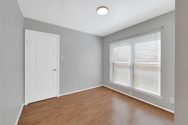 empty room featuring baseboards and wood finished floors