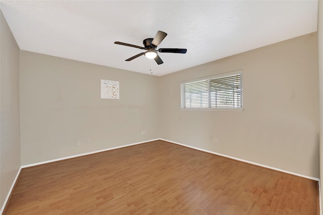 spare room with ceiling fan, baseboards, and wood finished floors