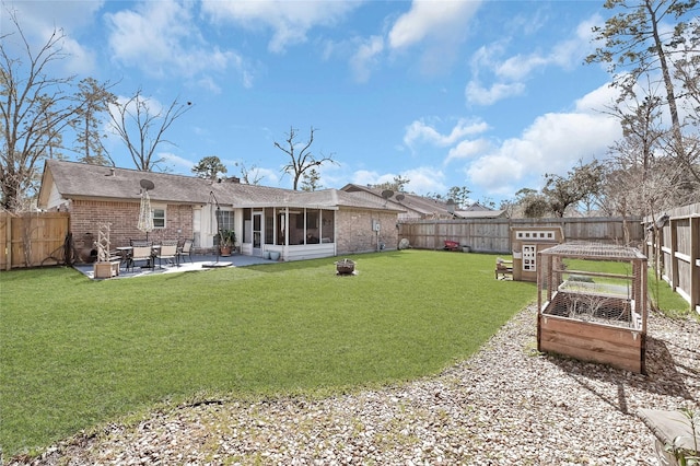 rear view of house with brick siding, a patio area, and a fenced backyard