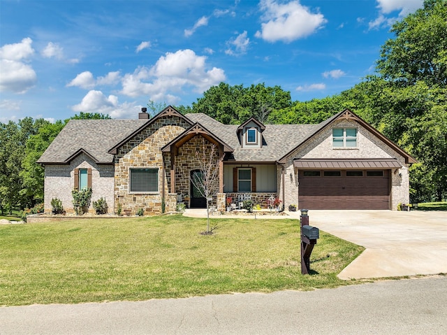 french country inspired facade with a garage, a front yard, roof with shingles, and driveway