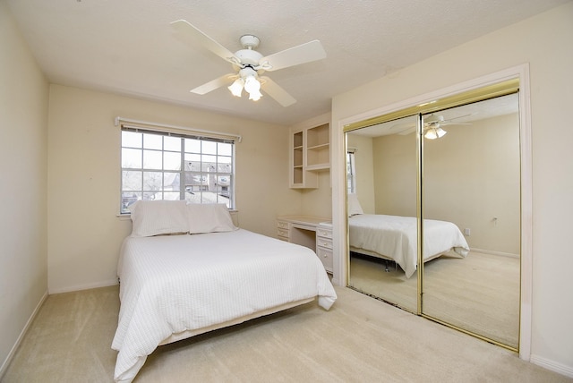 bedroom featuring a closet, ceiling fan, light carpet, and baseboards