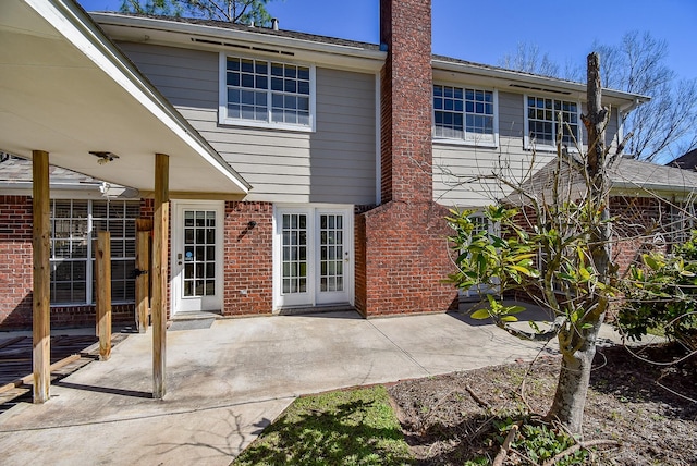 rear view of house featuring brick siding and a patio area