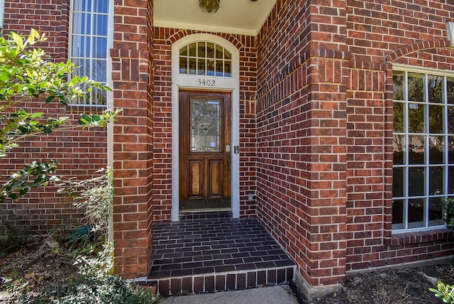 doorway to property featuring brick siding