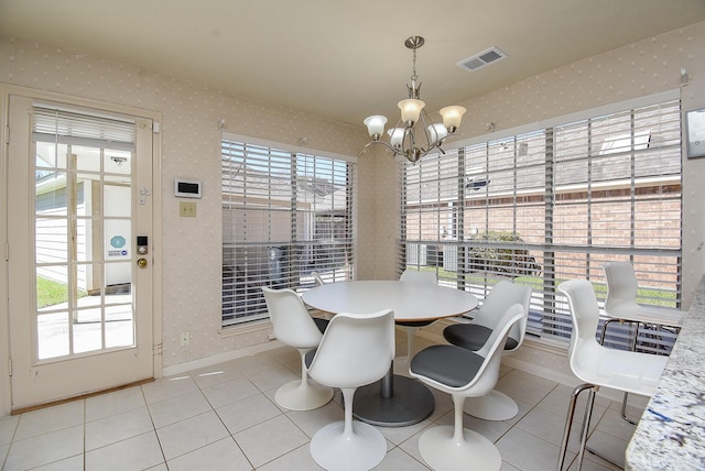 tiled dining area with visible vents, wallpapered walls, baseboards, a chandelier, and a wealth of natural light