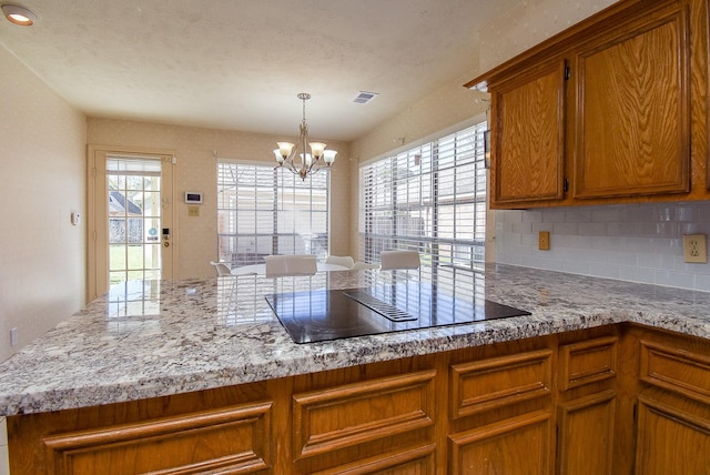 kitchen with visible vents, an inviting chandelier, plenty of natural light, and black electric cooktop