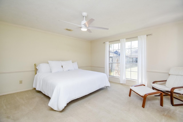 bedroom with visible vents, crown molding, baseboards, light carpet, and a ceiling fan