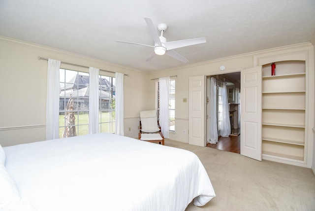 carpeted bedroom featuring ceiling fan, a textured ceiling, and ornamental molding