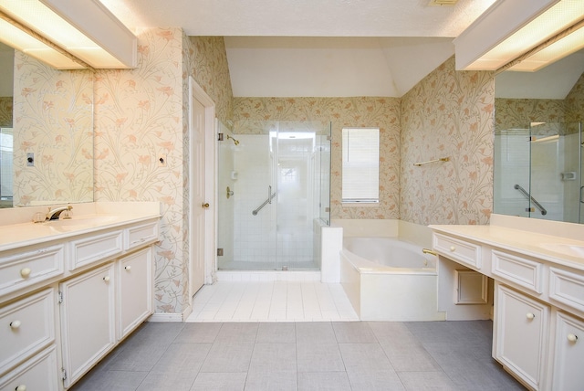 bathroom with a shower stall, wallpapered walls, two vanities, and a sink