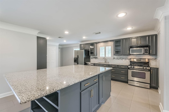 kitchen featuring ornamental molding, a sink, backsplash, a center island, and stainless steel appliances