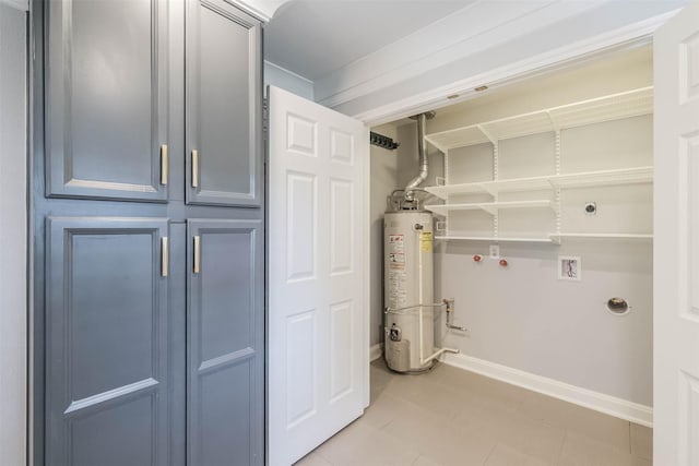 laundry room featuring gas water heater, baseboards, hookup for a washing machine, and laundry area