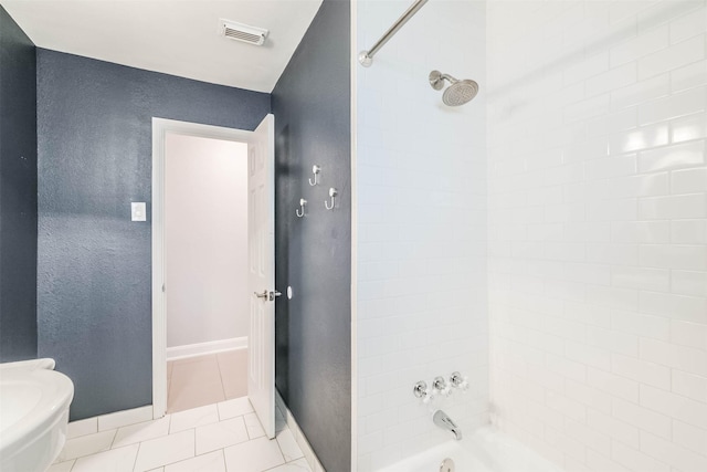 bathroom with tile patterned flooring, visible vents, baseboards, toilet, and washtub / shower combination