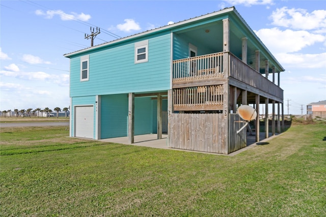 rear view of house featuring a garage, metal roof, and a lawn