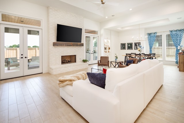 living area with recessed lighting, french doors, a healthy amount of sunlight, and a brick fireplace