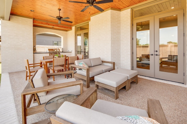 view of patio / terrace featuring ceiling fan, an outdoor living space, exterior kitchen, and french doors