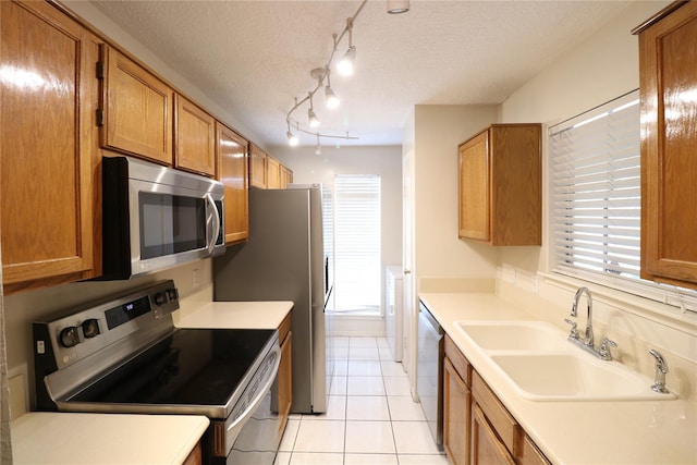 kitchen with a textured ceiling, appliances with stainless steel finishes, plenty of natural light, and a sink