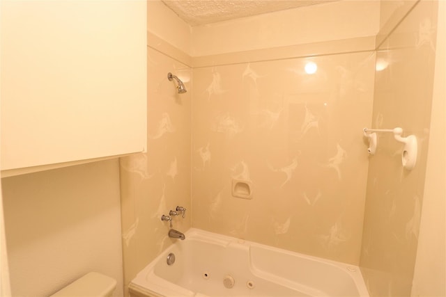 bathroom featuring washtub / shower combination, a textured ceiling, and toilet