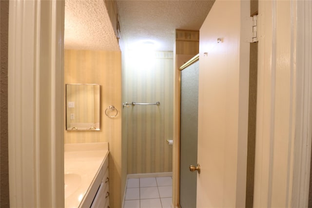 bathroom with tile patterned flooring, vanity, a textured ceiling, and a shower with shower door