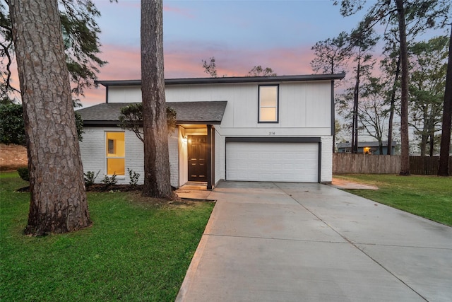 view of front of home featuring brick siding, concrete driveway, an attached garage, fence, and a front lawn