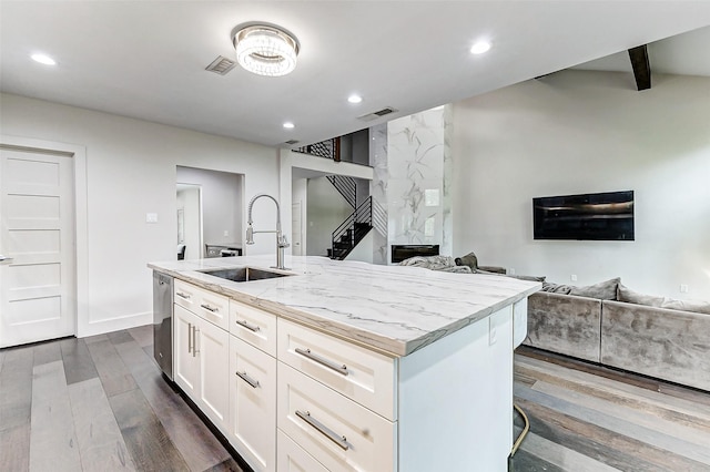 kitchen featuring visible vents, open floor plan, white cabinetry, a sink, and dishwasher