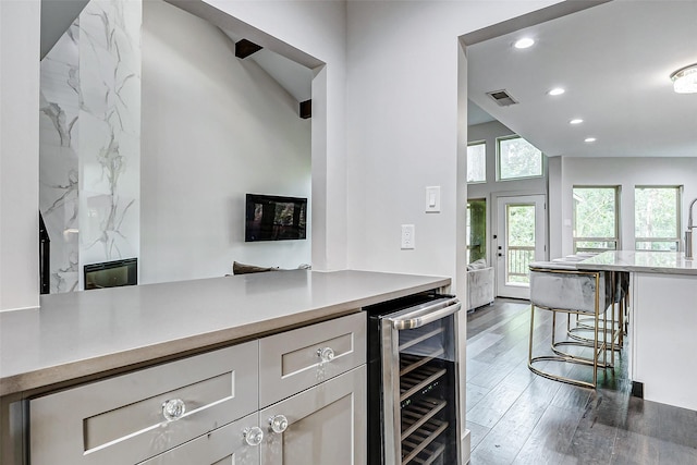 kitchen with wine cooler, recessed lighting, light countertops, visible vents, and wood finished floors